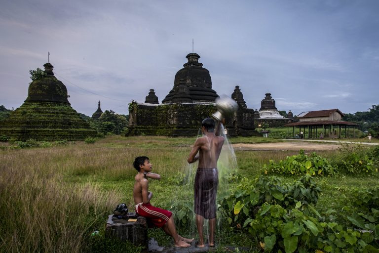 Children shower near a pagoda in Mrauk-U, Rakhine State on 21 August 2020. (Hkun Lat I Frontier)