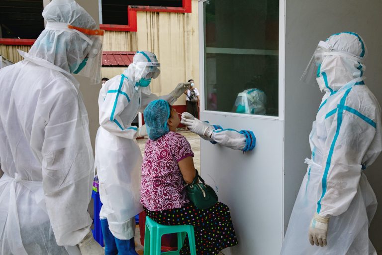 Medical workers take a swab sample from a patient with COVID-19-like symptoms at the Insein Fever Clinic on October. (Hkun Lat I Frontier)