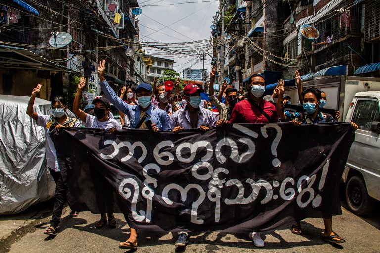 A group of protesters carries a banner reading, "Who are we? We are the people of Yangon," during a strike in the former capital, April 23, 2021. (Mar Naw | Frontier)