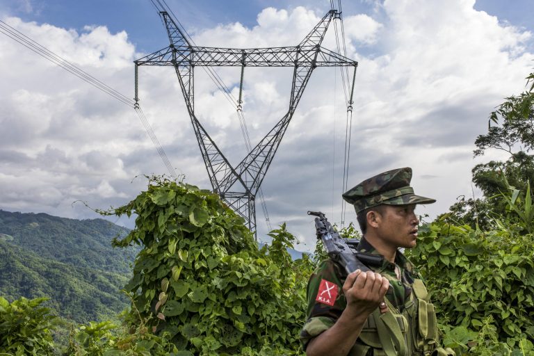 Kachin Independence Army soldiers stand on a mountain near powerlines. Photo by Hkun Lat