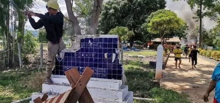 A resistance fighter smashes the signboard for the Moebyel police station on May 23 after it was seized that day by members of the local People's Defence Force.