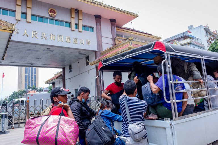 Myanmar migrant workers returning from China board a vehicle at the border town of Muse in northern Shan State on May 12, 2020. (AFP)