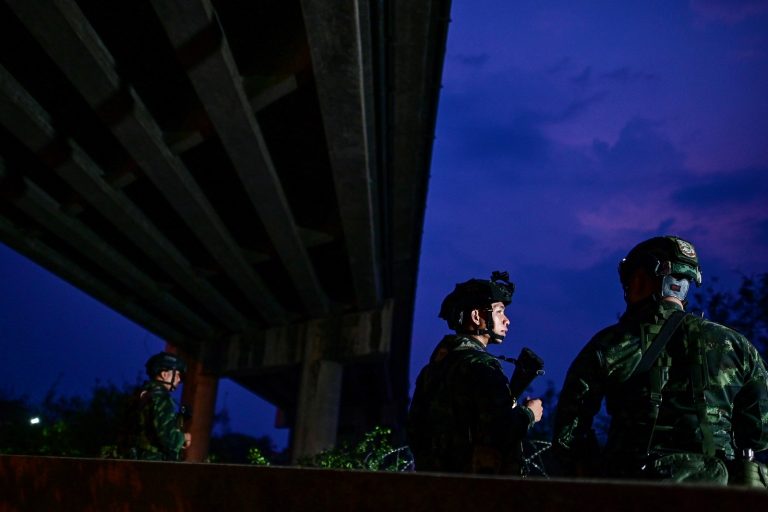 Thai soldiers stand guard near the Moei River separating Thailand and Myanmar, on the other side of Kayin State’s Myawaddy town, last night. (AFP)