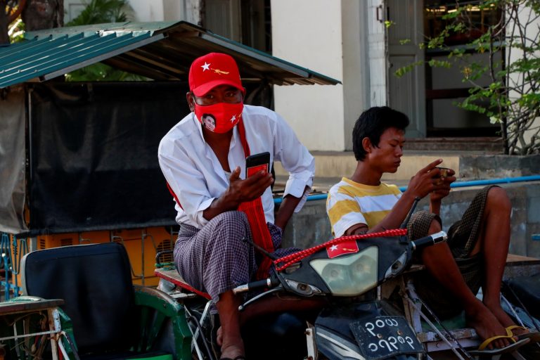 A motorcycle taxi driver campaigns in Mandalay for the National League for Democracy before it was overthrown in a coup. (Frontier)