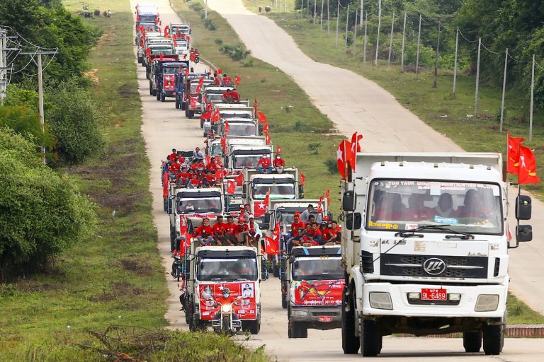 National League for Democracy supporters ride in trucks during a campaign rally in Nay Pyi Taw on October 21. (Thet Aung | AFP)