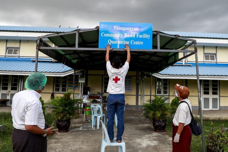 Myanmar Red Cross Society staff put up a sign at a quarantine facility in Yangon's Thingangyun  Township on September 10. (Nyein Su Wai Kyaw Soe | Frontier)