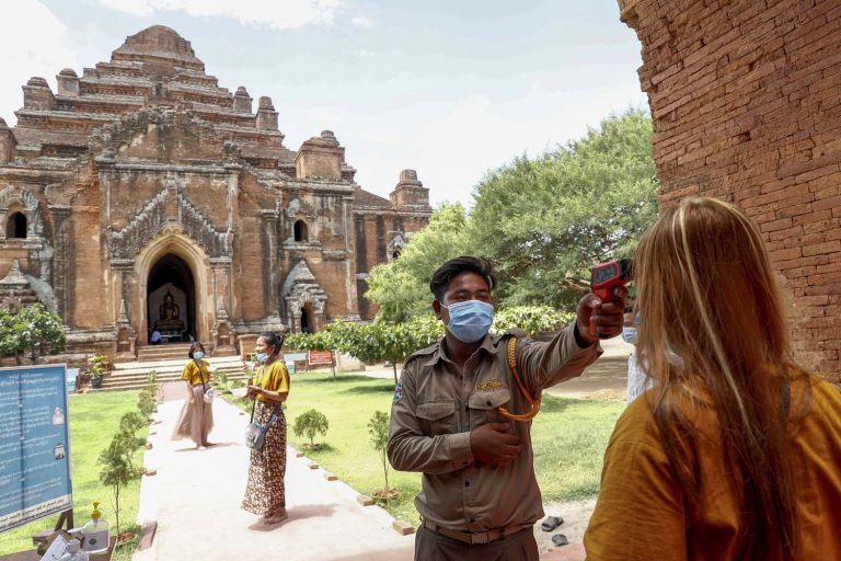 A security guard at the Dhammayangyi temple checks the temperatures of the small number of visitors, many of whom come from nearby towns in Mandalay and Magway regions, such as Kyaukpadaung and Pakokku. (Nyein Su Wai Kyaw Soe | Frontier)