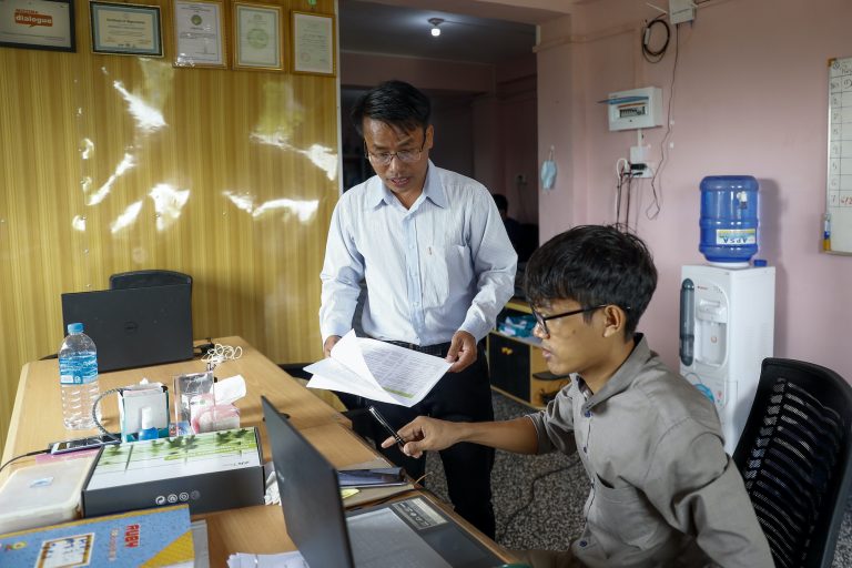 Ko Chan Lian, center, executive director of the domestic election observation group the Hornbill Organization – seen here with a coworker at the group's office in East Dagon Township, Yangon on July 14 – said the coronavirus has seriously hobbled the group's plans for the November election. (Nyein Su Wai Kyaw Soe | Frontier)