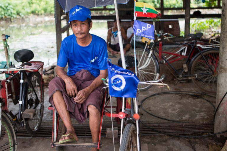 A Mayangone trishaw driver waits for customers while clad in People's Pioneer Party gear. (Thuya Zaw | Frontier)