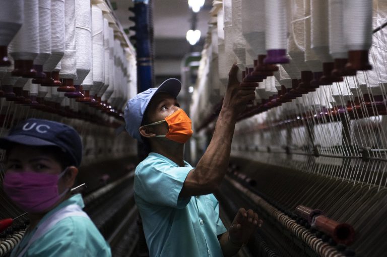 Myanmar migrant workers hand cotton thread spools in a textile factory in Thailand’s Pathum Thani province on September 23, 2018. (AFP)