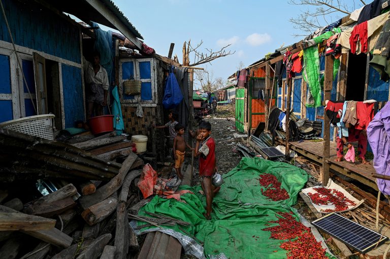 Rohingya children stand by destroyed houses at Ohn Taw Chay camp in Sittwe on May 16, two days after Cyclone Mocha's landfall. (AFP)