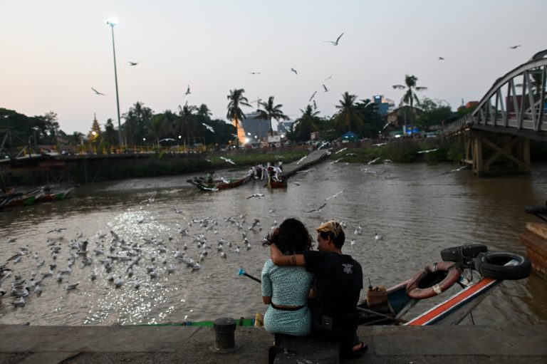 A young couple sits at the Botahtaung jetty in Yangon on April 5, 2020. (AFP)