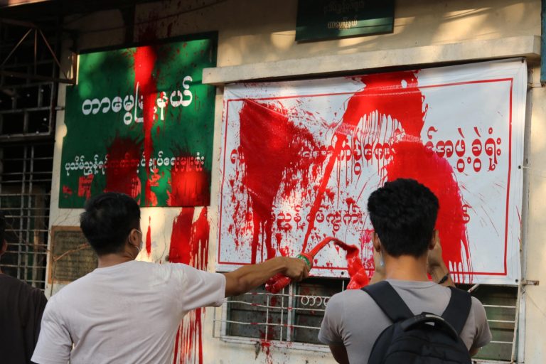 Protesters splash red paint on a local administration building during a demonstration against the military regime in Yangon’s Tarmwe Township on April 11, 2021. (AFP)