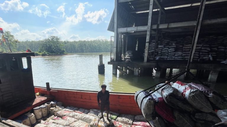Sacks of Myanmar charcoal are unloaded in a waterside warehouse in the Thai port town of Ranong in December 2023. (Frontier)
