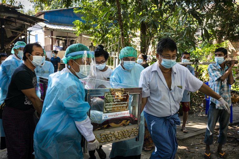 Volunteers with Yangon's Free Funeral Service Society transport a body from the deceased's home to the Yayway cemetery on December 11, 2020. (Hkun Lat | Frontier)