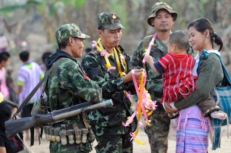 Soldiers from the Karen National Union greet a local mother and her child.