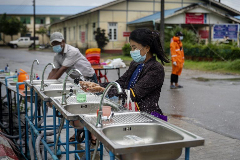 A woman washes her hands at the entrance to Sittwe General Hospital in Rakhine State on August 24. (Hkun Lat | Frontier)