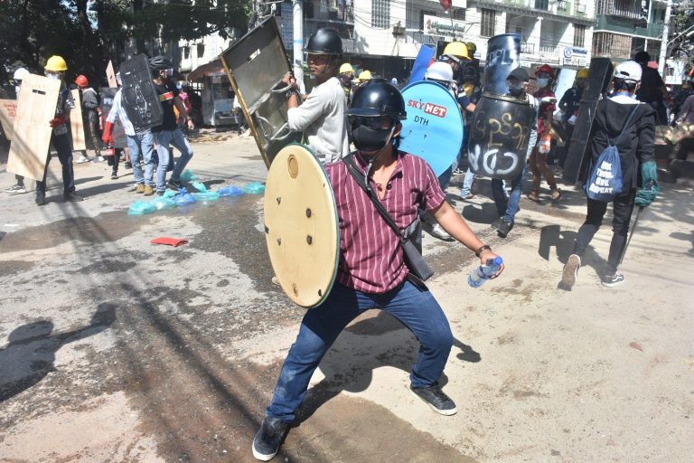 A protester in Yangon's Sanchaung Township holds up a makeshift shield to protect from police batons and rubber bullets on March 4. (Frontier)