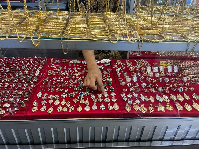 Vendor displays her wares at a gold shop at Insein Market in Yangon taken July 3, 2021. (Frontier)