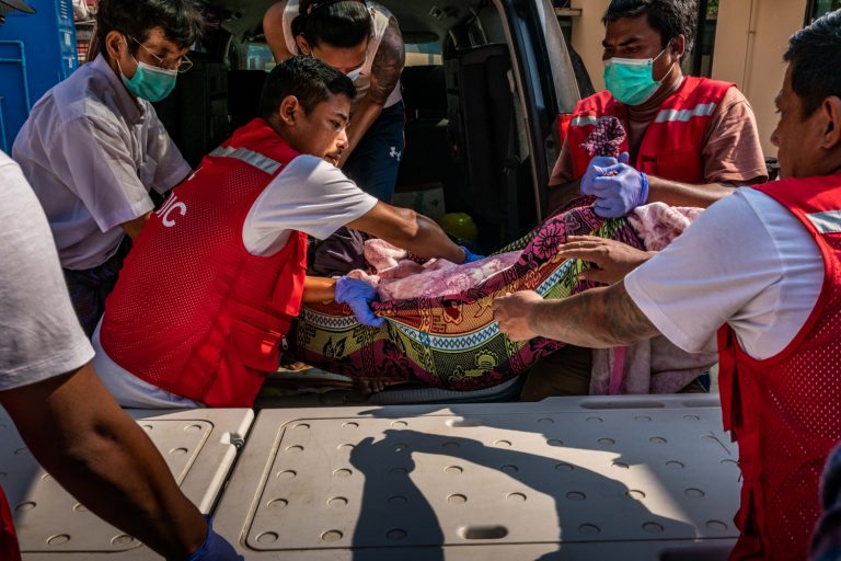 Volunteer medics carry the body of a protester killed by security forces during a crackdown on a demonstration in Yangon on March 27. (Frontier)